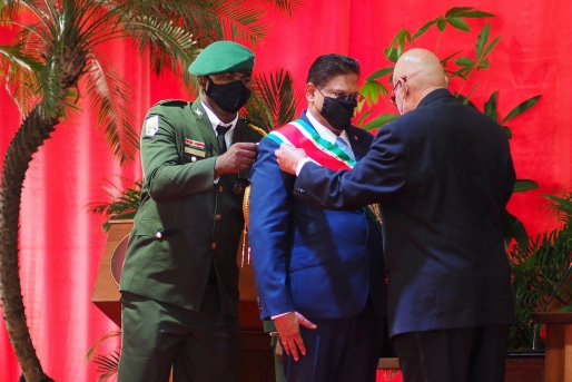 De nieuwe president van Suriname, Chan Santokhi, ontvangt de presidentiële sjerp tijdens zijn inauguratie.Beeld AP De nieuwe president van Suriname, Chan Santokhi, ontvangt de presidentiële sjerp tijdens zijn inauguratie.Beeld AP